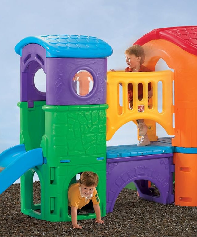 مجموعة ألعاب خارجية للأطفال من ستيب2 كلوب هاوس كلايمبر (برايتس) من عمر سنتين إلى ست سنوات، مزودة بمنزلقات مزدوجة، وسلّم تسلق، ونفق زحف، وبرج مراقبة، ومجموعات ألعاب ومعدات ملعب.